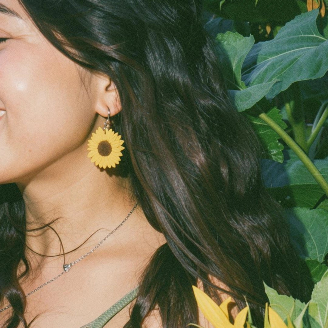 Girl wearing handmade sunflower huggies earrings