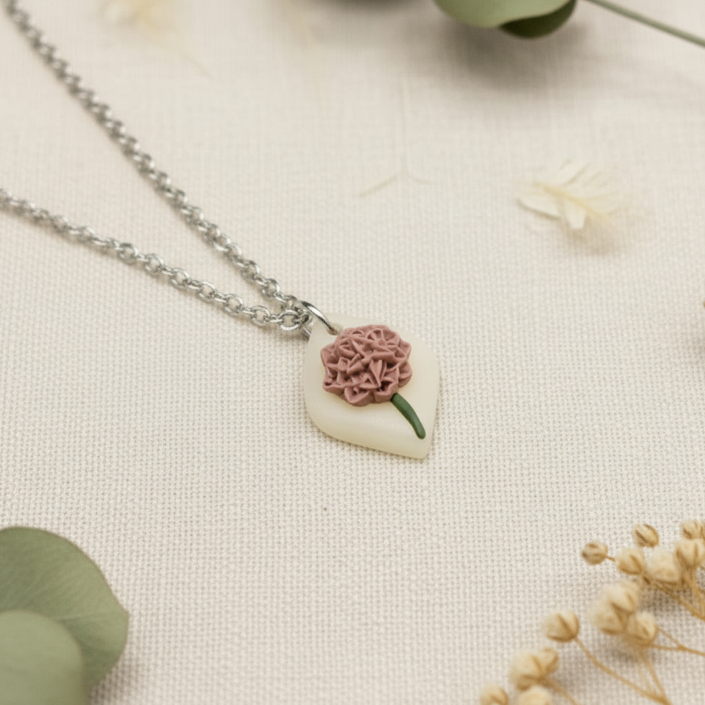 Necklace with a diamond-shaped pendant featuring November birth flower on a light fabric background.