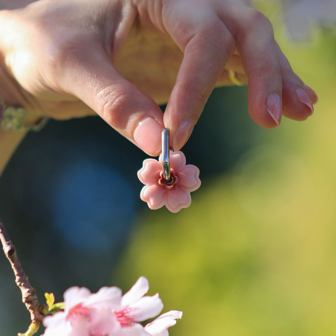 close up of handmade polymer clay cherry blossom earrings with sunlight