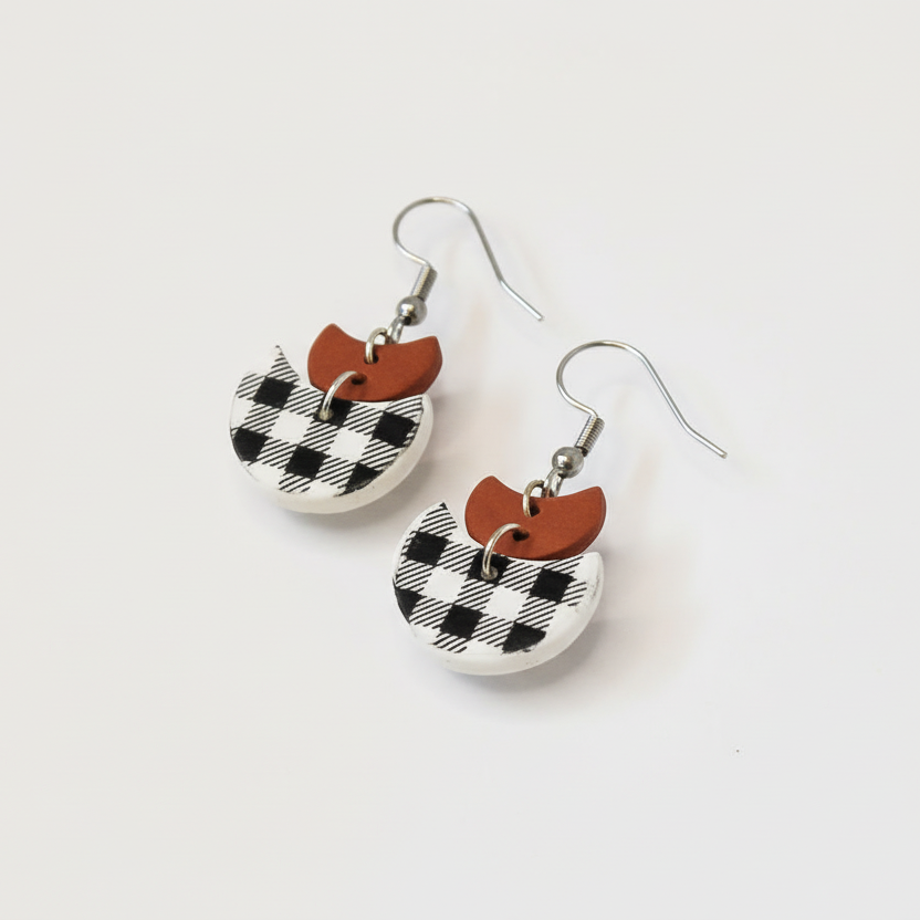 Pair of earrings with checkered design on a white background
