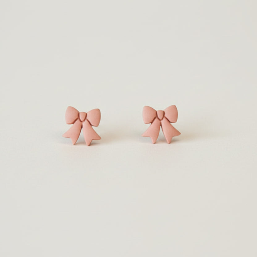 Bow stud earrings made with polymer clay in soft peach | NZ made jewellery