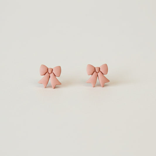 Bow stud earrings made with polymer clay in soft peach | NZ made jewellery