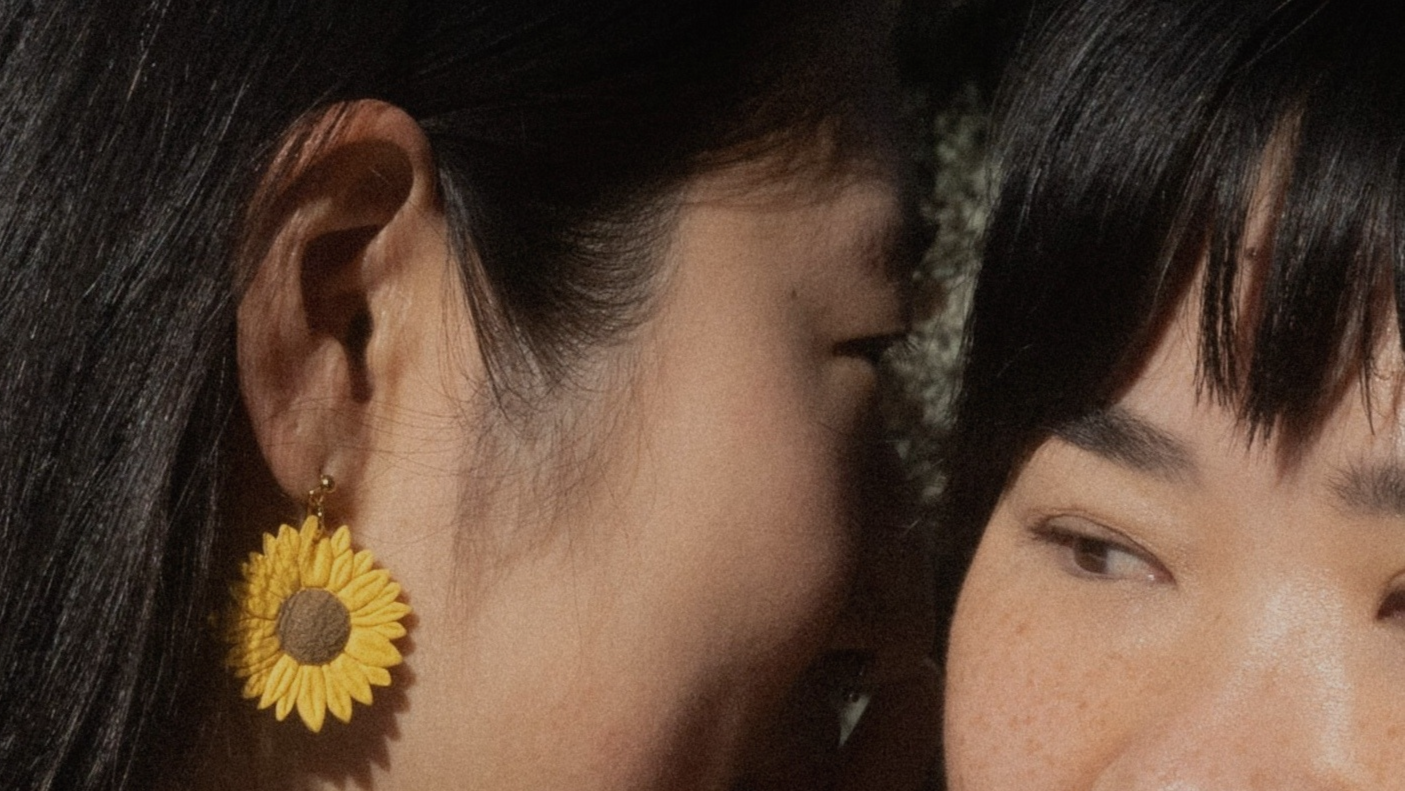 girl wearing sunflower earrings by Arias Design Co